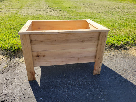 Wooden planter box on a paved surface with grass in the background in Marysville Ohio