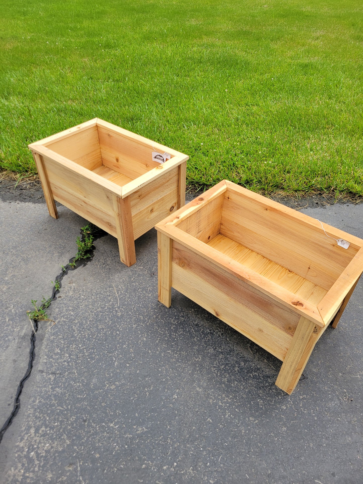 Two wooden planters on a grassy and paved surface. Apartment Balcony