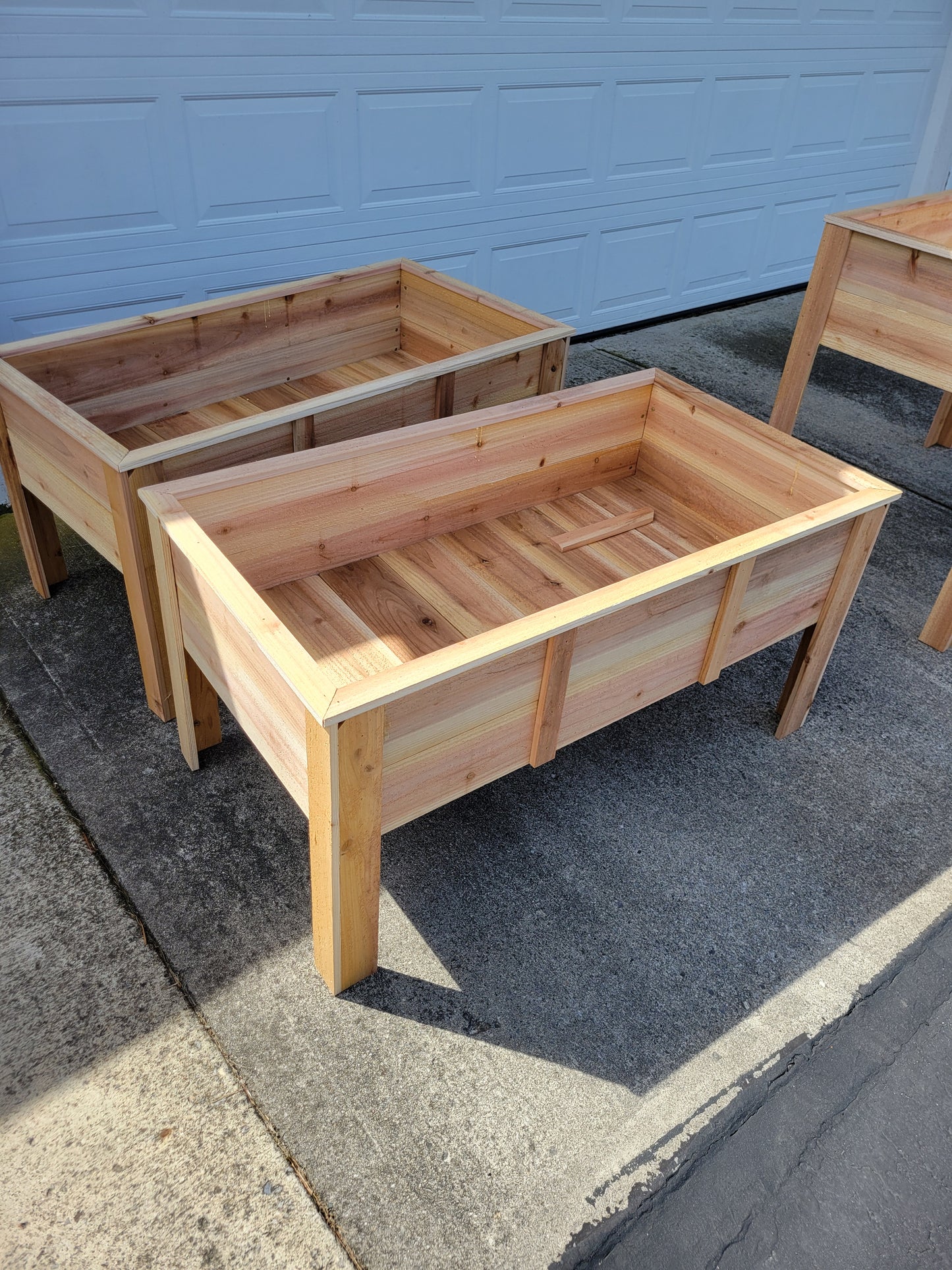 Wooden planter boxes on a concrete surface.  raised garden bed.