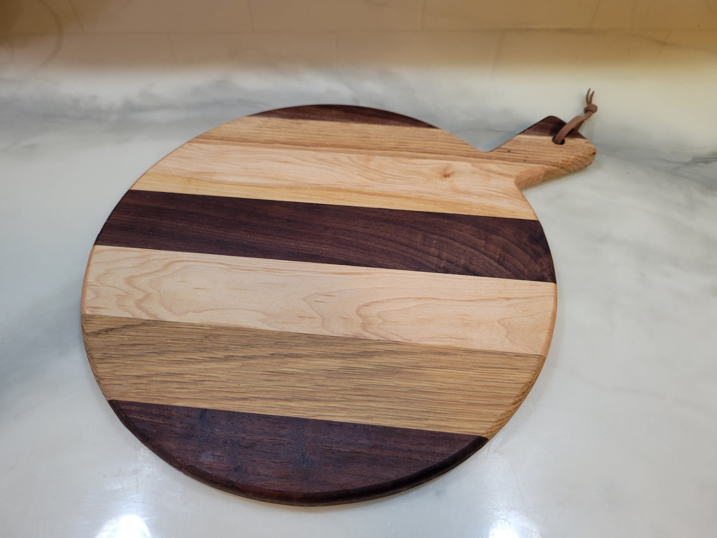 Wooden cutting board with a handle on a white surface