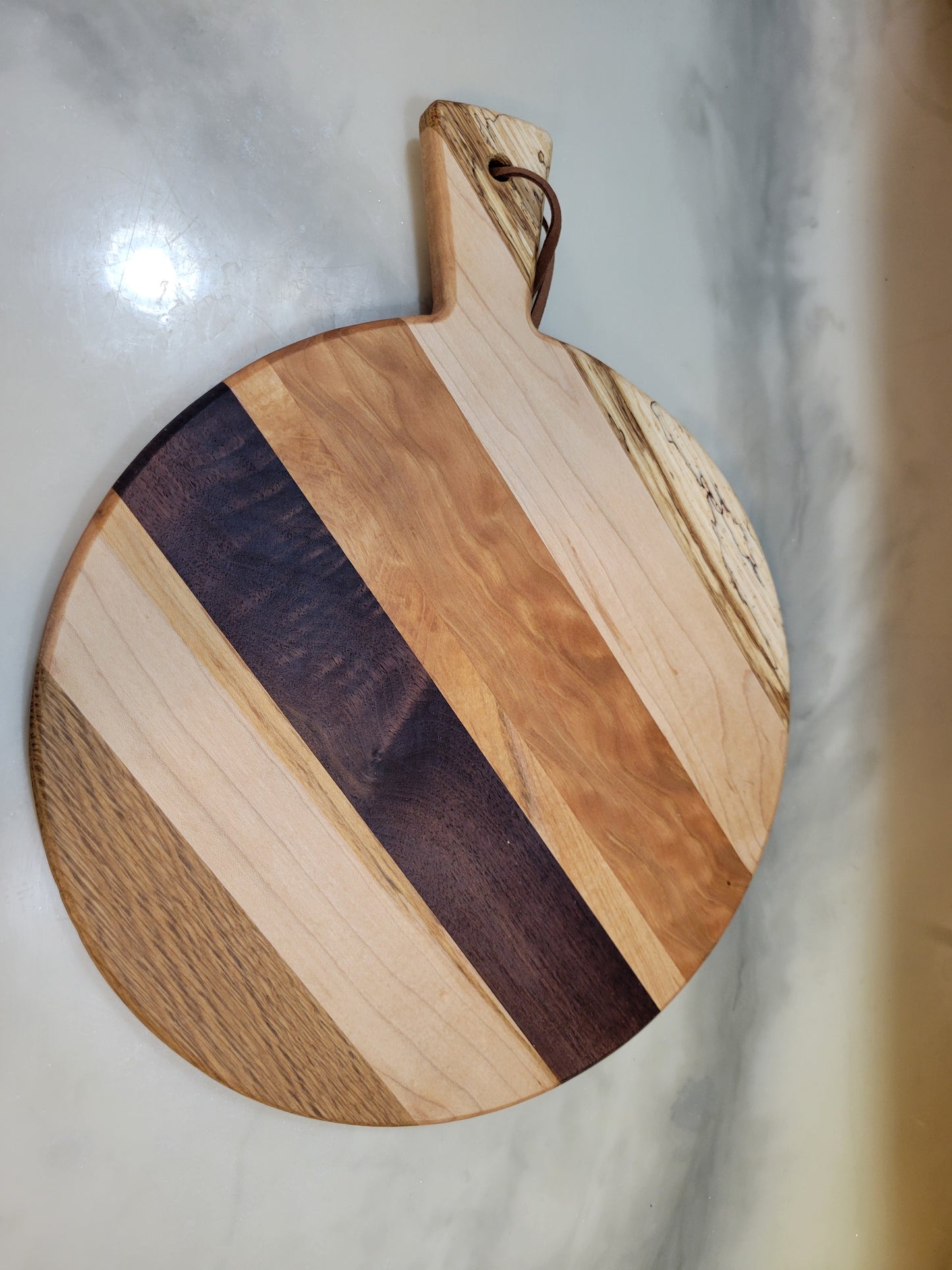 Wooden cutting board with a handle perfect for a marble surface kitchen