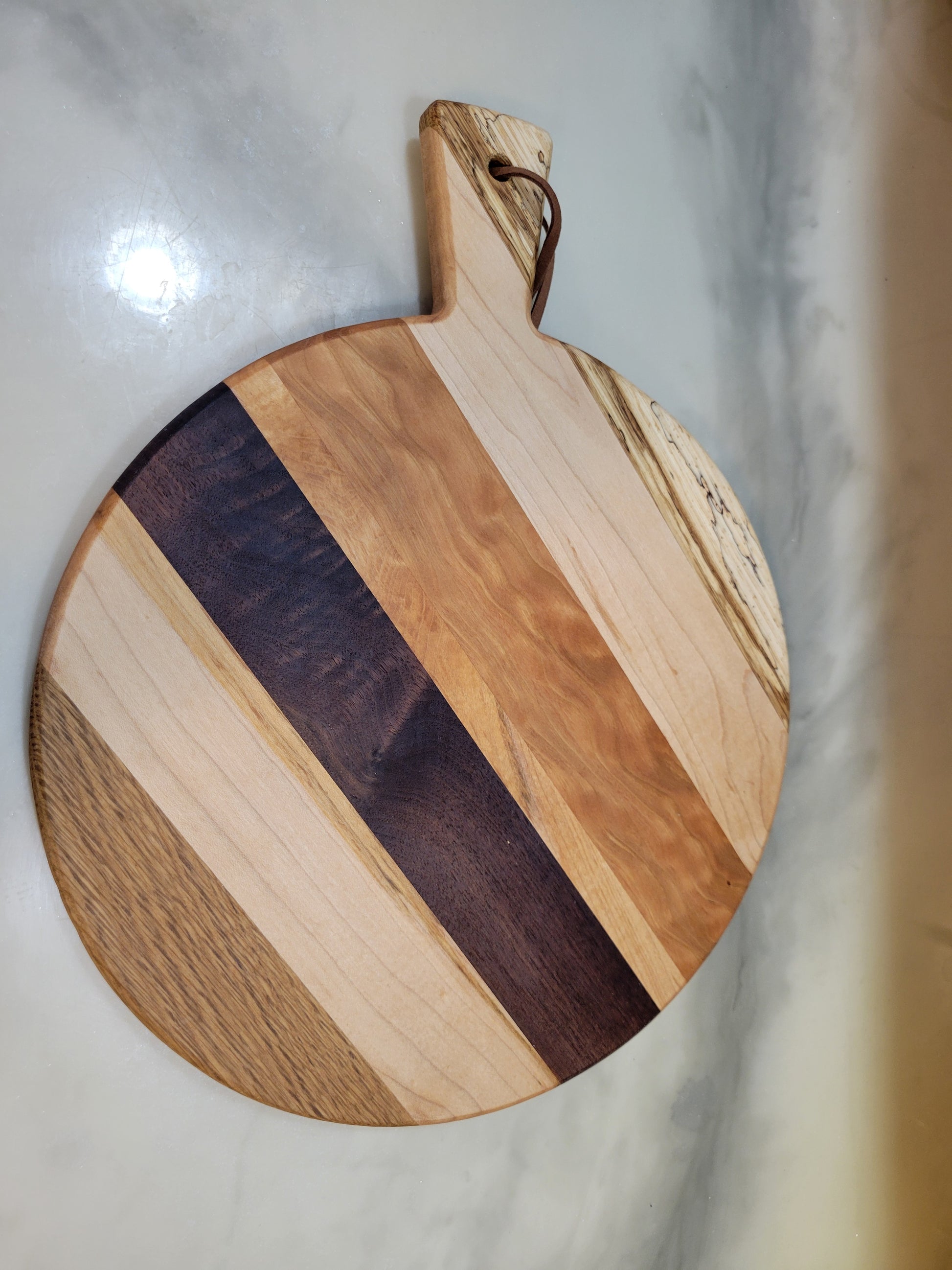 Wooden cutting board with a handle perfect for a marble surface kitchen